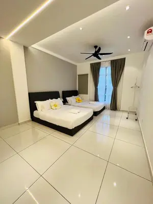 a bedroom with two beds and a ceiling fan at Inn Homestay 1st Floor Unit in Teluk Intan