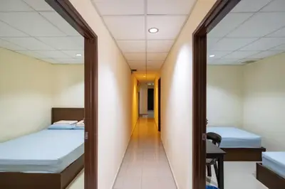 a corridor of a room with two beds and a mirror at CLP perai homstay in perai in Perai