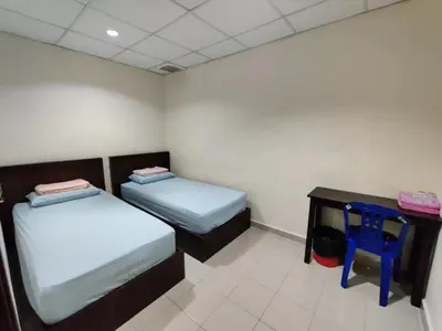 a room with two beds and a table with a stool at CLP perai homstay in perai in Perai