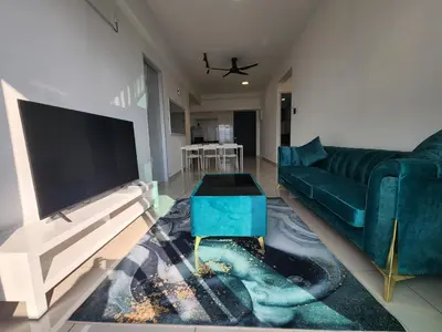a living room with a blue couch and a tv at Praicon Executive Suite in Butterworth