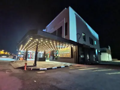 a building with lights on the side of it at night at 1 Day Car Hotel - BG Perdana in Batu Gajah