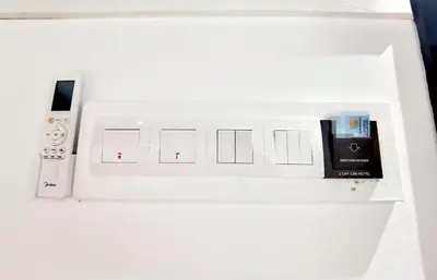 a white switch board with a remote control and a remote control at 1 Day Car Hotel - BG Perdana in Batu Gajah