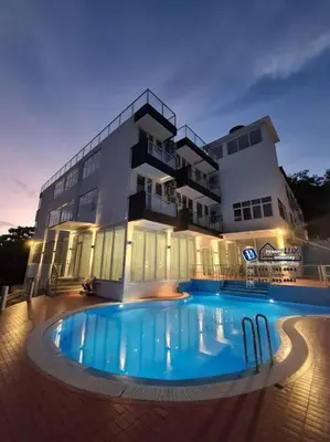 a large building with a swimming pool in front of a building at Villa w/PrivatePool Golf View Snooker BBQ 10BR in Bayan Lepas