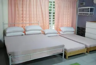 two beds in a room with pink curtains at D'RUMAH BONDA RIVER VIEW Kuala Kangsar in Kampong Senawar