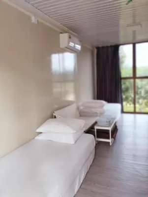 a white room with two beds and a couch at D'RUMAH BONDA RIVER VIEW Kuala Kangsar in Kampong Senawar